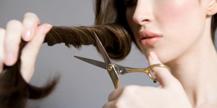 девушка обрезает себе волосы