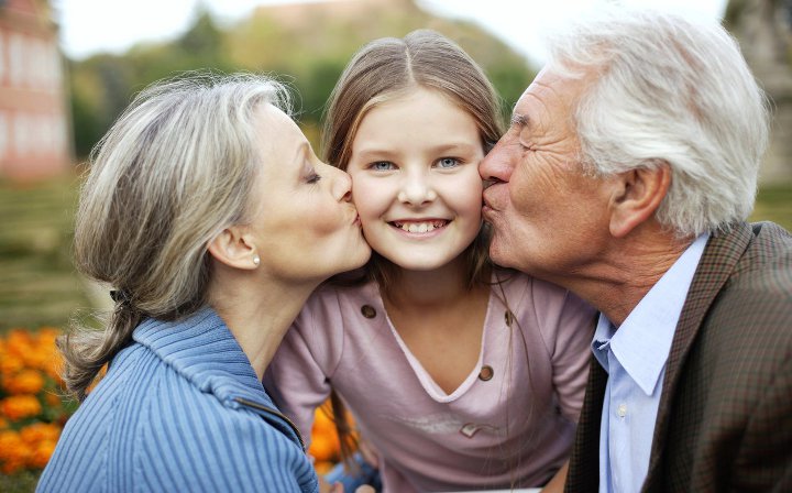 бабушка и дедушка целуют внучку